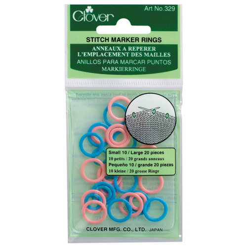 Clover brand Stitch Marker Rings in a clear plastic hanging package with a green header card. The rings are small in size, shown in pink, blue, and white, with a circular diagram on the packaging illustrating their use.
