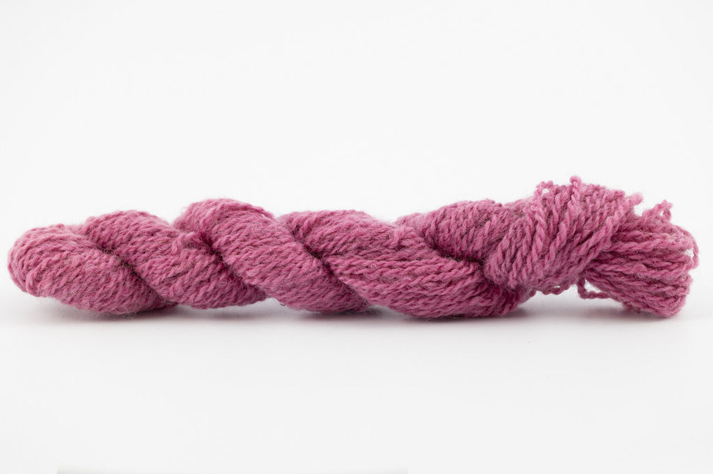 A purple skein of Wensleydale Muga silk naturally dyed with cochineal.