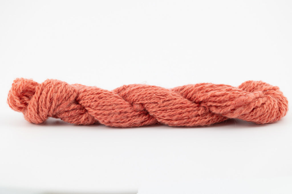 A coral skein of Wensleydale Muga silk naturally dyed with madder root.