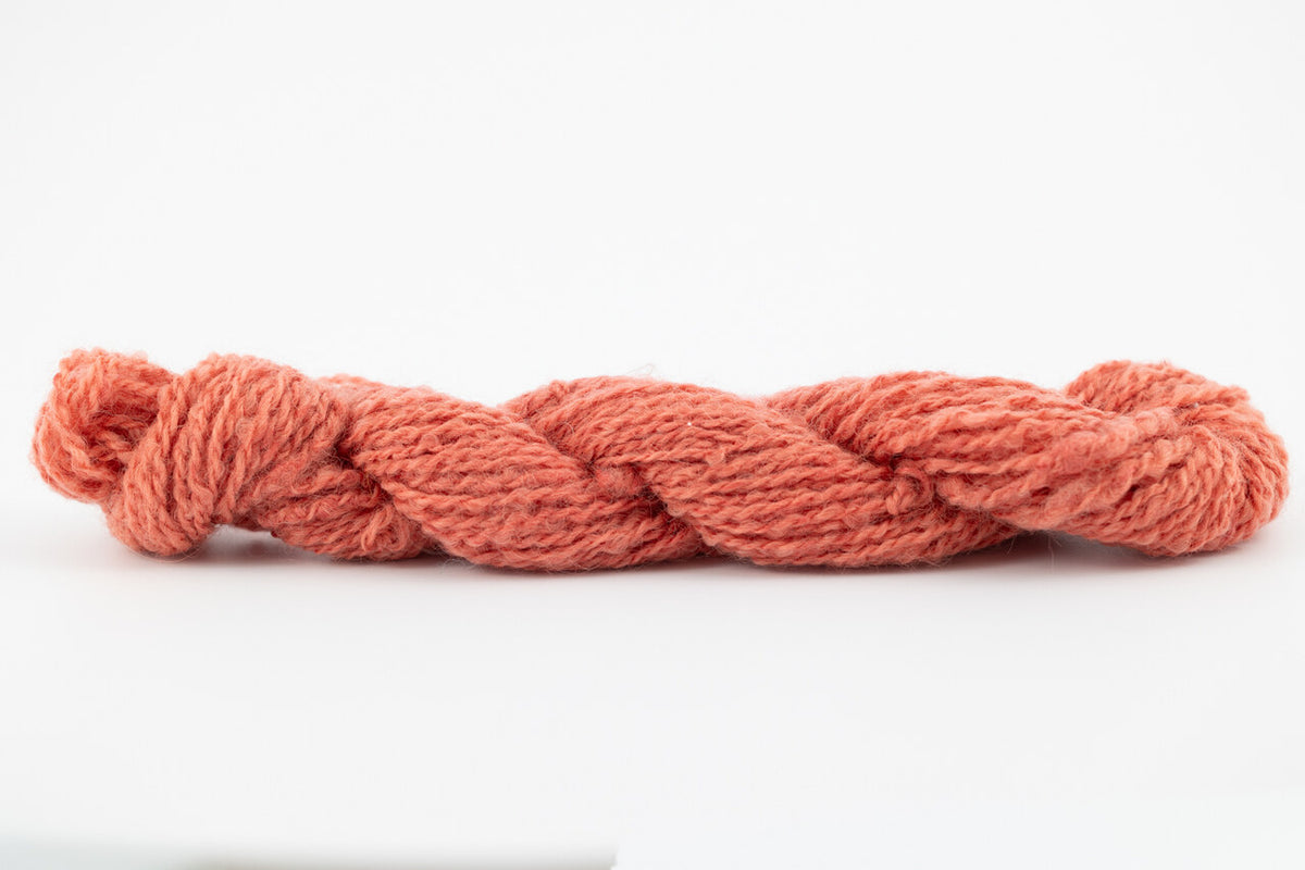 A coral skein of Wensleydale Muga silk naturally dyed with madder root.