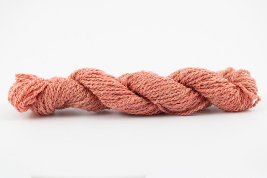 A light coral skein of Wensleydale Muga silk naturally dyed with madder root.