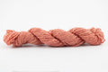 A light coral skein of Wensleydale Muga silk naturally dyed with madder root.