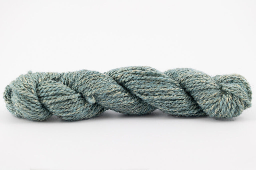 A skein of teewater and muga silk naturally dye with indigo to light blue color.