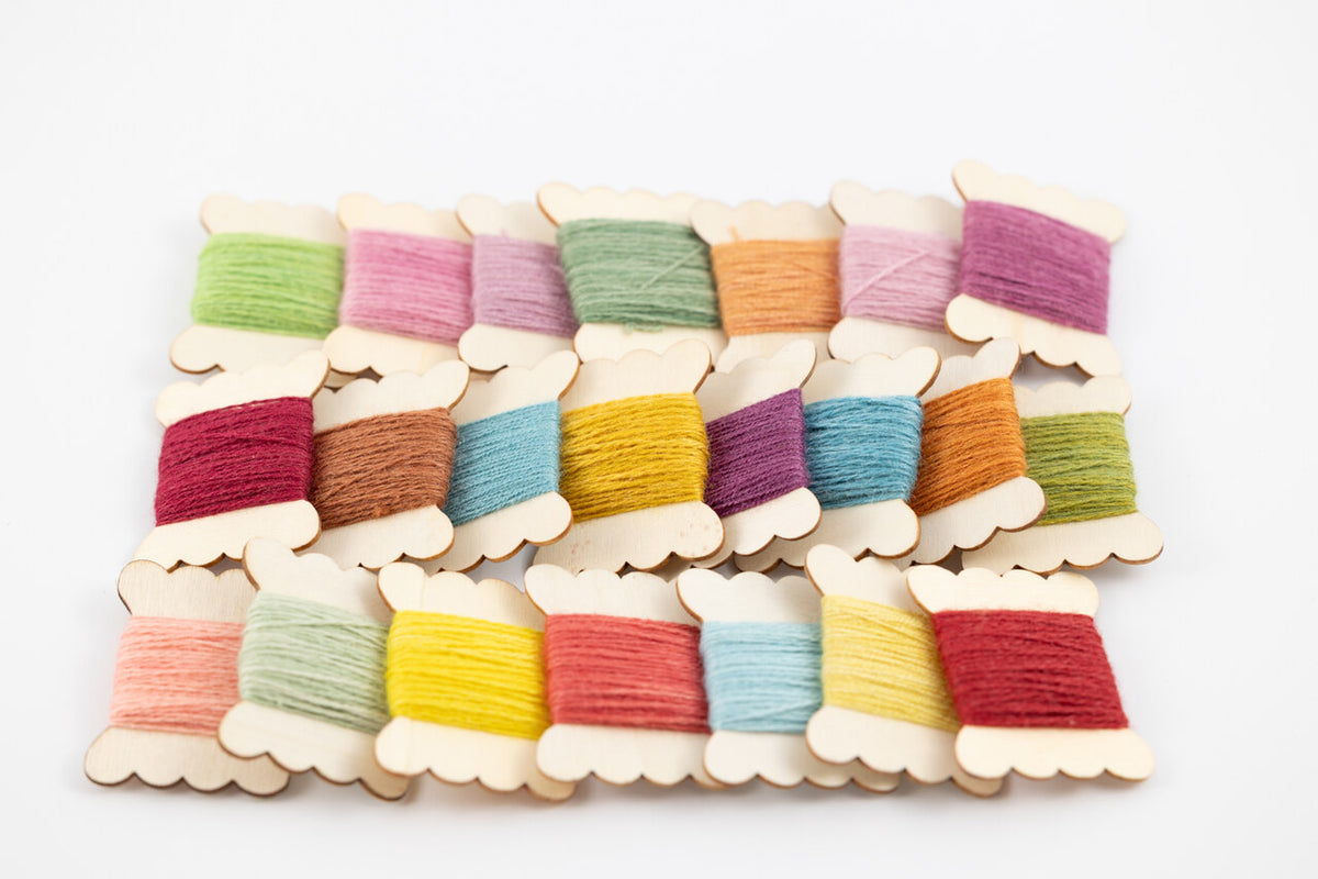 A set of 15 wooden spools of thread in various pastel and bright colors, arranged in a grid on a clean white background.