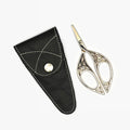 Decorative scissors with a black leather sheath on a white background