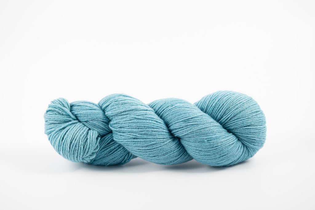 A skein of shaniko wool naturally dyed with indigo to a light blue color.