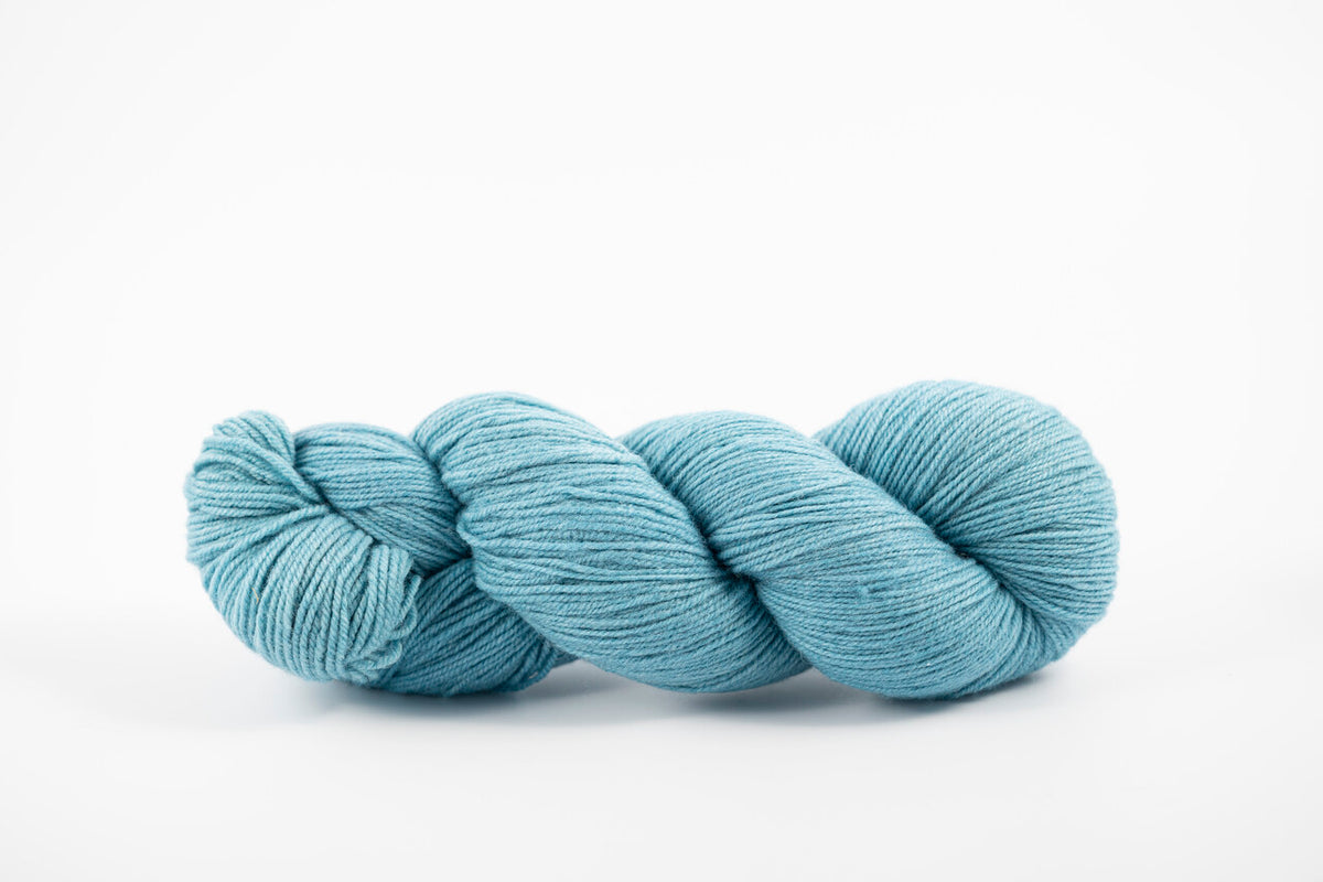 A skein of shaniko wool naturally dyed with indigo to a light blue color.