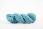 A skein of shaniko wool naturally dyed with indigo to a light blue color.