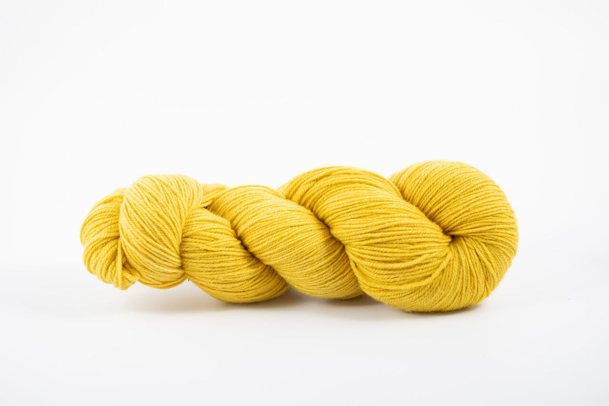 A skein of shaniko wool naturally dyed with marigold to a yellow color.