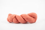 A skein of shaniko wool naturally dyed with lac to persimmon orange color.