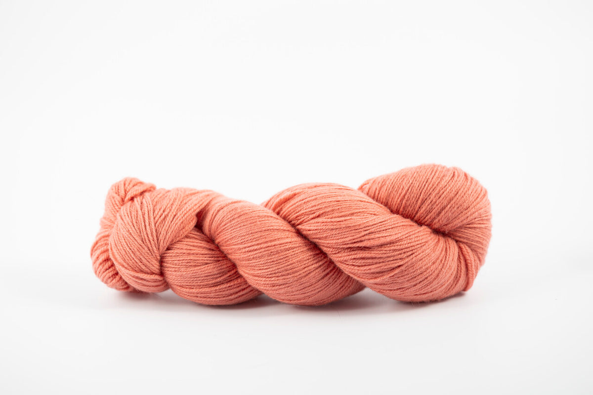 A skein of shaniko wool naturally dyed with lac to persimmon orange color.