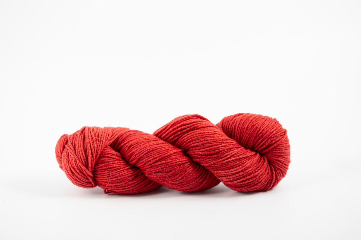 A skein of shaniko wool naturally dyed with madder root to a deep red color.
