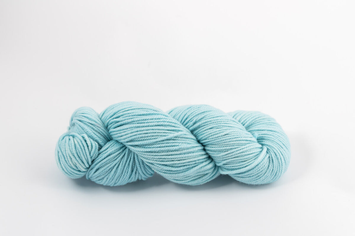 A light blue skein of Shaniko wool and silk worsted weight yarn naturally dyed with indigo.