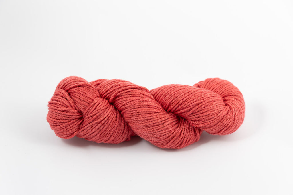 A light red skein of Shaniko wool and silk worsted weight yarn naturally dyed with sappanwood.