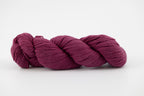 A purple skein of Shaniko wool and silk yarn naturally dyed with cochineal.