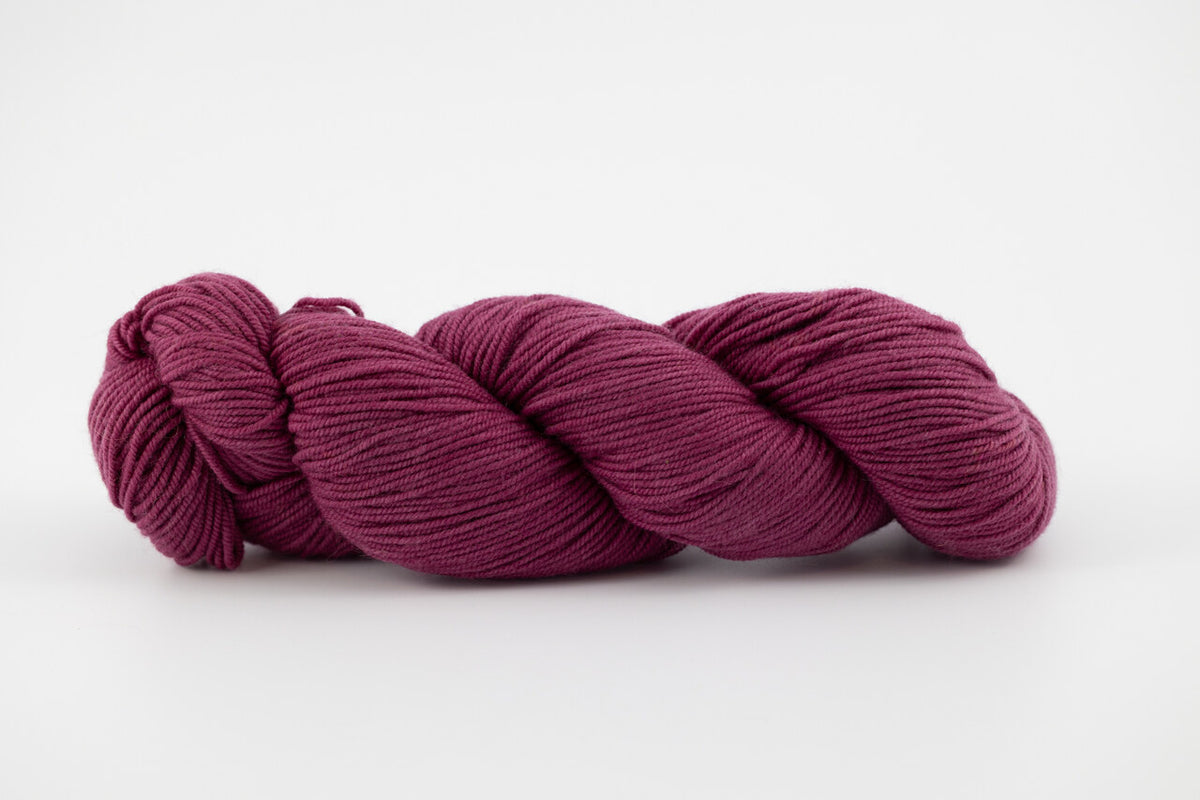 A purple skein of Shaniko wool and silk yarn naturally dyed with cochineal.