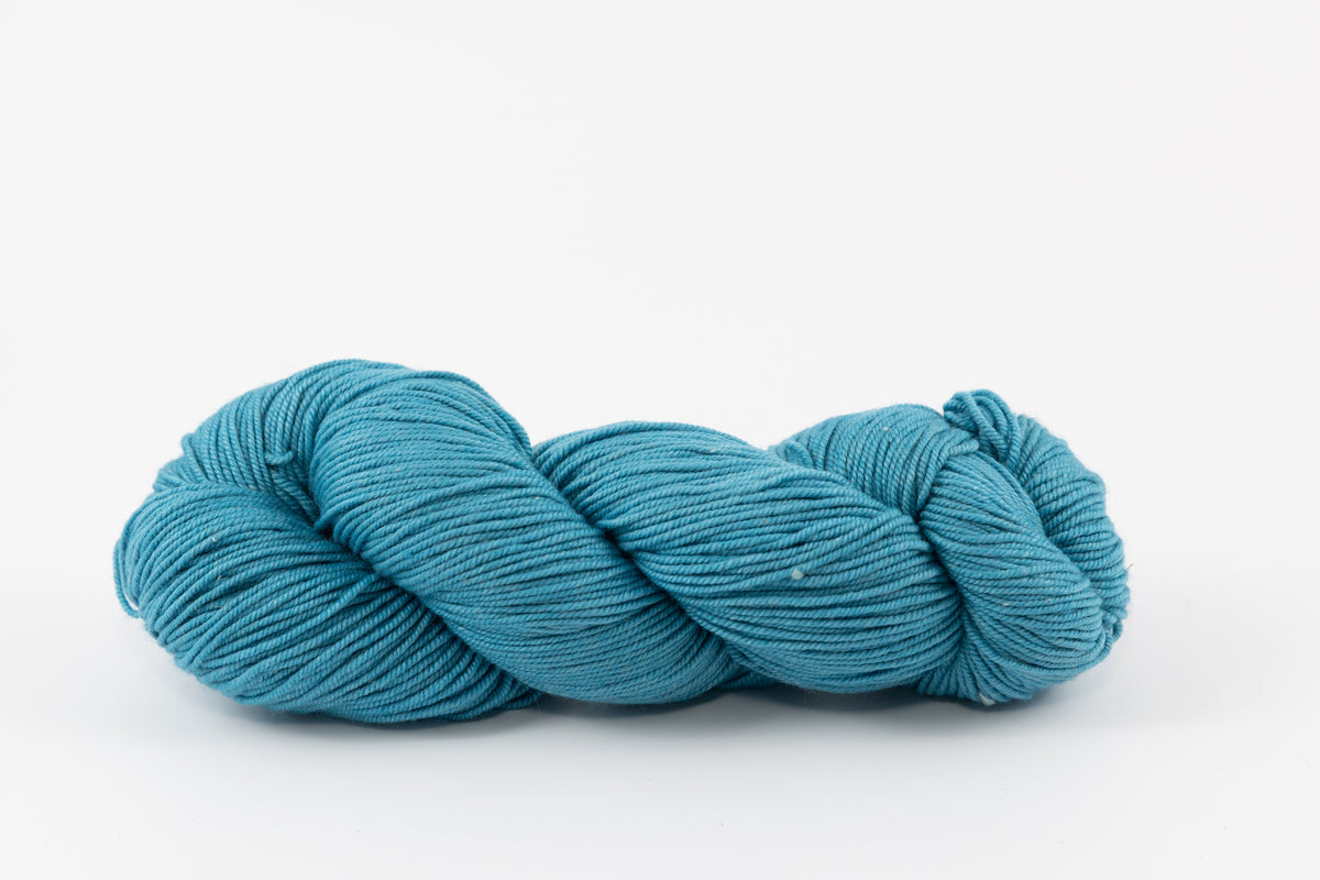 A blue skein of Shaniko wool and silk yarn naturally dyed with indigo.