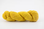 A yellow skein of Shaniko wool and silk yarn naturally dyed with orange osage. 