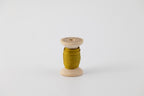 A spool of naturally dyed silk ribbon dyed with indigo and marigold to a chartreuse color.  