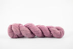 A skein of a blend of corriedale and gotland wool naturally dyed with lac to a light purple color.